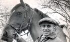 Willie Carson holds a horse's bridle